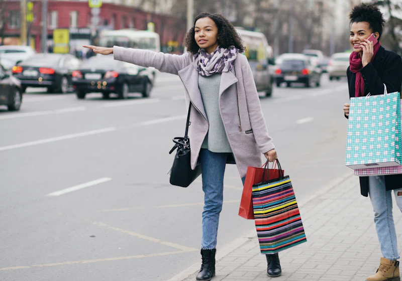 Two people hailing a ride on a city street